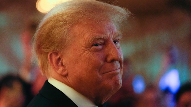 Former president Donald Trump smiles toward guests, as he arrives to speak at an event at Mar-a-Lago, Friday, November 18, 2022, in Palm Beach, Florida.