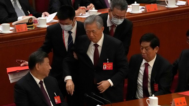 Former Chinese President Hu Jintao, centre, is helped during the closing ceremony of the 20th National Congress of China's ruling Communist Party at the Great Hall of the People in Beijing, Saturday, Oct. 22, 2022.  