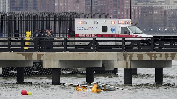 First responders stand on a pier at the scene where a helicopter crashed into the Hudson River, Thursday, April 10, 2025, in Jersey City, N.J. (AP Photo/Seth Wenig)