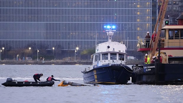 Divers investigate the scene where a helicopter crashed into the Hudson River, Thursday, April 10, 2025, in Jersey City, N.J. (AP Photo/Seth Wenig)