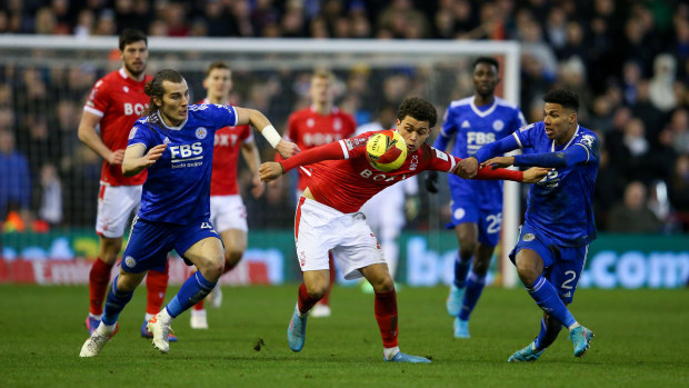 Djed Spence of Nottingham Forest is challenged by Caglar Soyuncu and James Justin of Leicester City.