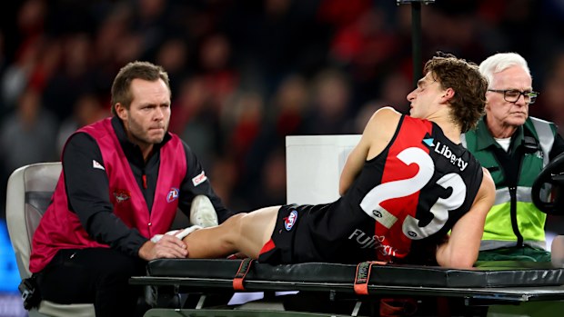 Harrison Jones of the Bombers leaves the field on a stretcher.