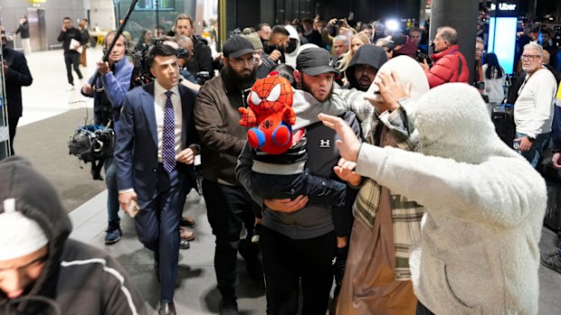 MELBOURNE, AUSTRALIA - MAY 07: A group of supporters surround an Islamic State-linked family as they arrive at Melbourne Airport on May 07, 2026 in Melbourne, Australia. The women, who had traveled to Syria to join the Islamic State militant group, are expected to face questioning by Australian Federal Police upon their arrival, with authorities weighing potential charges under counter-terrorism legislation. (Photo by Asanka Ratnayake/Getty Images)
