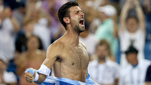 Novak Djokovic of Serbia tears his shirt off after defeating Carlos Alcaraz of Spain.