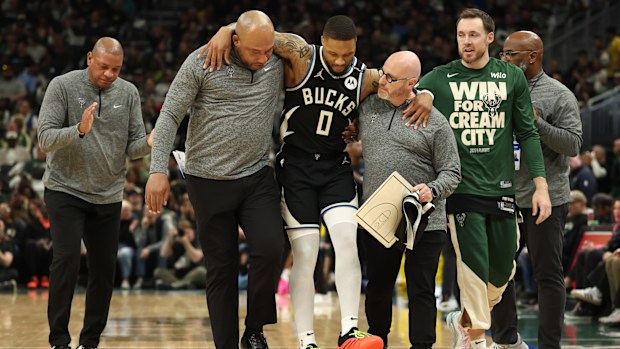 Damian Lillard of the Milwaukee Bucks is helped off the court after an achilles injury during the first quarter in Game Four of the Eastern Conference First Round NBA Playoffs against the Indiana Pacers.