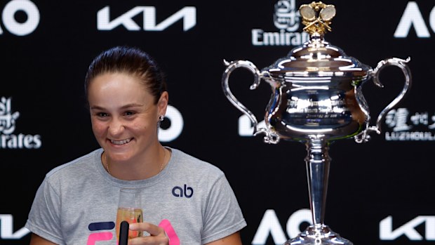 Ash Barty of Australia drinks a glass of champagne at a press conference after defeating Danielle Collins
