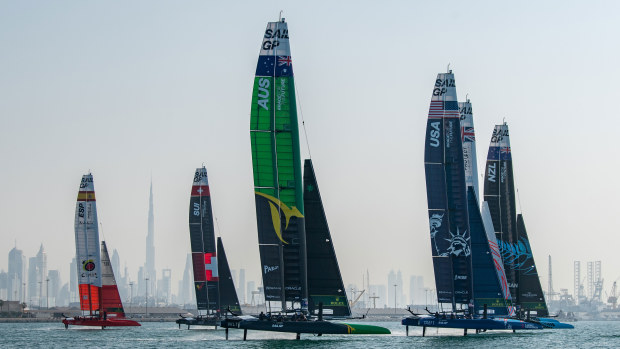 Australia SailGP Team helmed by Tom Slingsby and the fleet sail past the Burj Khalifa and Dubai skyline during a practice session.