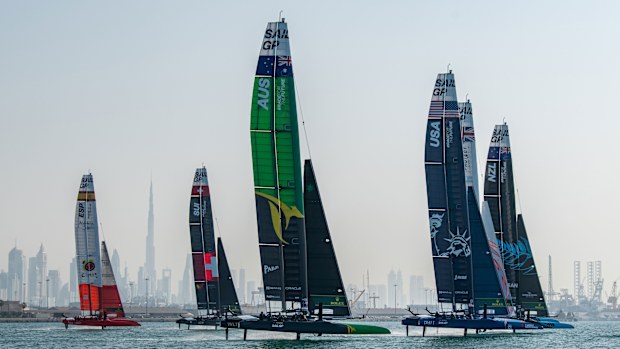 Australia SailGP Team helmed by Tom Slingsby and the fleet sail past the Burj Khalifa and Dubai skyline during a practice session.