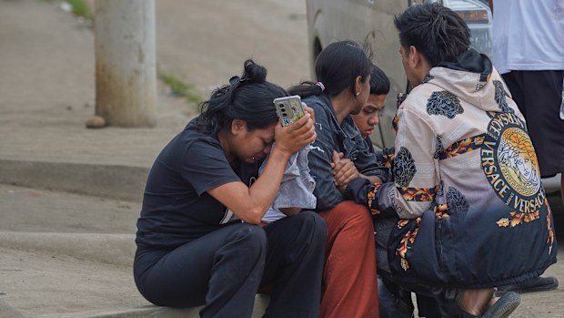 Relatives of prisoners who died during clashes between inmates wait for the remains of their loved ones outside the morgue in Machala, Ecuador, Monday, Nov. 10, 2025. (AP Photo/Cesar Munoz)