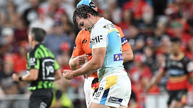 Kieran Foran of the Titans is assessed by the trainer after injuring his arm against the Dolphins.
