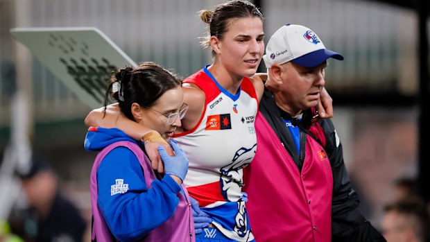 Alice Edmonds of the Bulldogs is assisted off the field by medical staff.