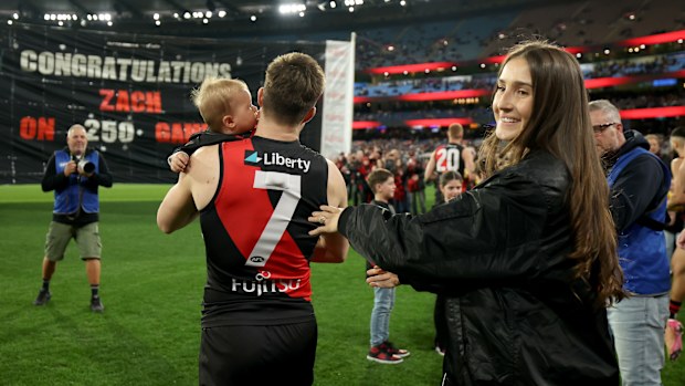 Zach Merrett de Bombers es felicitado por su esposa Alexandra y su hijo Jude durante su juego número 250.