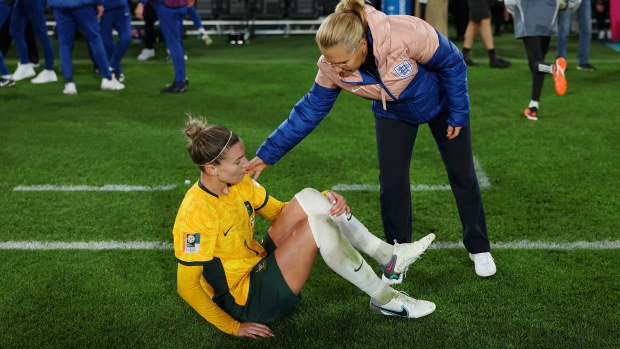 Matildas vice captain Steph Catley is consoled by England coach Sarina Wiegman after slumping to the turf after full-time.