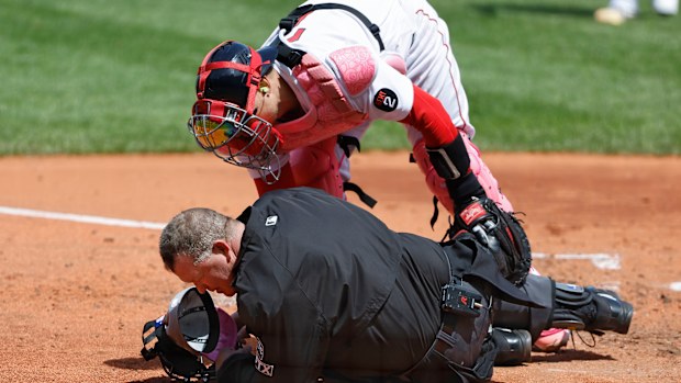 Boston's Christian Vazquez checks on umpire Ron Kulpa after he was struck by a foul ball.