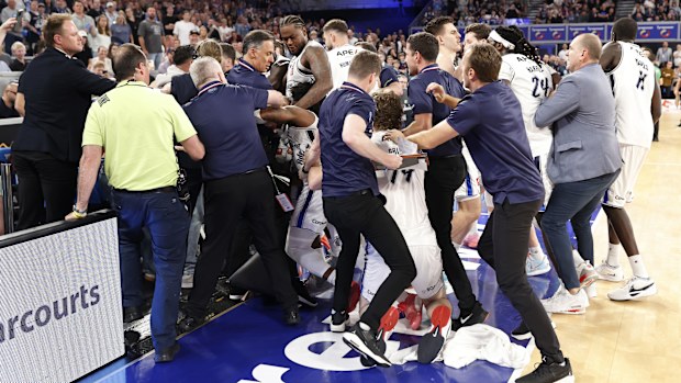 A fight breaks out on the Adelaide 36ers bench as member of the crowd clash with players.