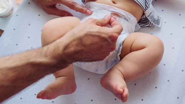 Father change diaper to baby boy on baby changing table