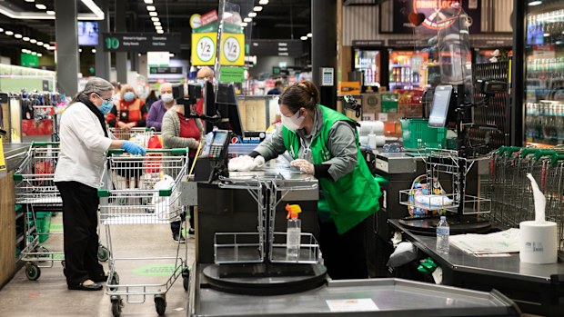 A staff member wipes down the checkout area at Woolworths 