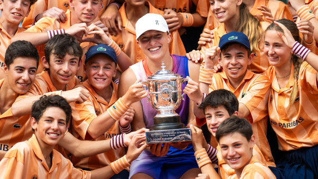 Iga Swiatek of Poland poses among ball kids with the champions trophy after defeating Jasmine Paolini of Italy in the womens singles final on Day 14 of the French Open at Roland Garros on June 08, 2024 in Paris, France (Photo by Robert Prange/Getty Images)