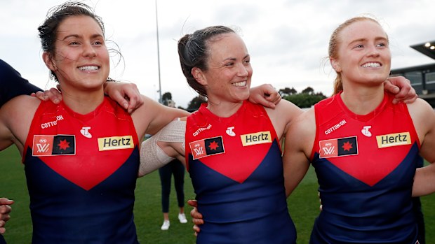 Libby Birch, Daisy Pearce and Blaithin Mackin of the Demons sing the team song.