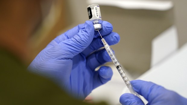 FILE - A healthcare worker fills a syringe with the Pfizer COVID-19 vaccine at Jackson Memorial Hospital on Oct. 5, 2021, in Miami. (AP Photo/Lynne Sladky, File)