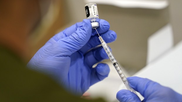 FILE - A healthcare worker fills a syringe with the Pfizer COVID-19 vaccine at Jackson Memorial Hospital on Oct. 5, 2021, in Miami. (AP Photo/Lynne Sladky, File)