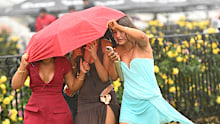 Three to an umbrella at Flemington racecourse.