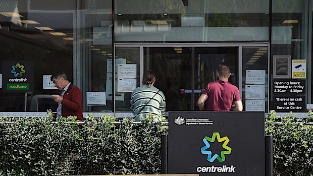 People wait outside a Services Australia outlet