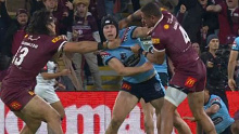 Dane Gagai of the Maroons throws a punch at Matt Burton of the Blues while he is held by Tino Fa'asuamaleaui.