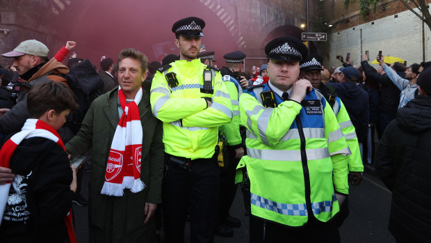 Police officers keep an eye on the fan march outside Emirates Stadium in London.