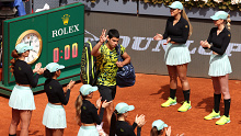 Carlos Alcaraz of Spain walks out onto the court in front of the Madrid Open ball girls.