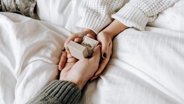 Stock image of a couple holding an engagement ring.