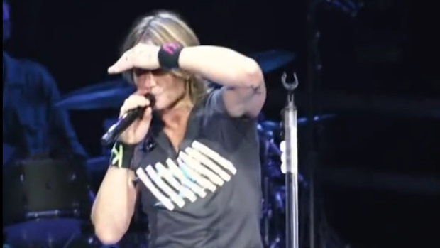 Keith Urban with fan on stage.