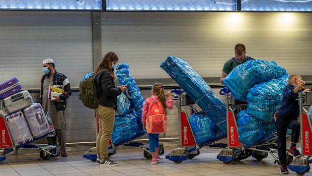 People lineup to get on an overseas flight at OR Tambos airport in Johannesburg, South Africa, Friday Nov. 26, 2021. 