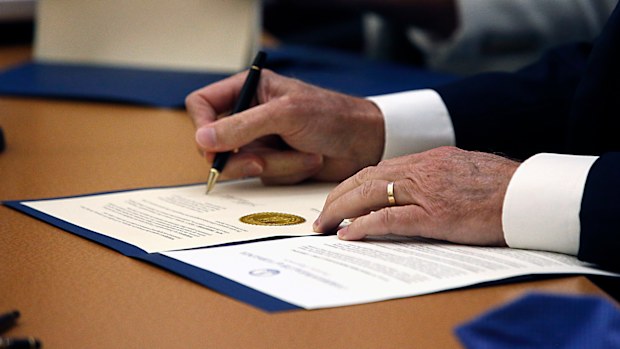 Virginia Governor Ralph Northam signs one of the posthumous pardons for the Martinsville Seven. 