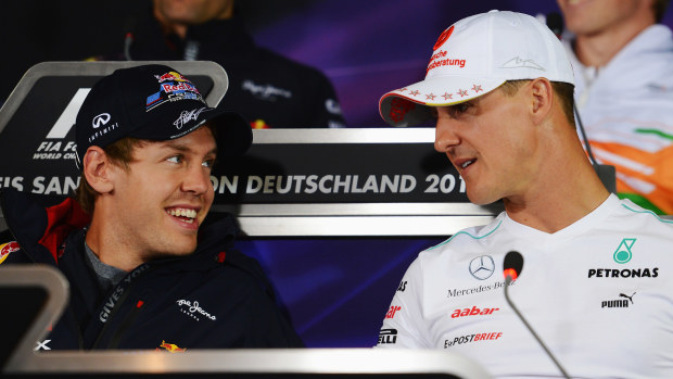 Sebastian Vettel (left) and Michael Schumacher speak before the 2012 German Grand Prix.