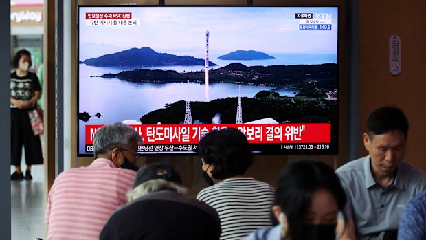 Passengers watch a TV broadcasting a news report on North Korea firing a space rocket, at a railway station in Seoul, South Korea.