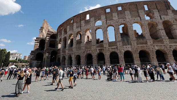 Tourists wait in a queue to enter the Colosseum in Rome, Italy.