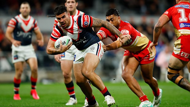 Terrell May of the Roosters attempts to break through.