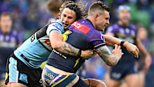 Cameron Munster of the Storm is tackled Nicho Hynes of the Sharks.
