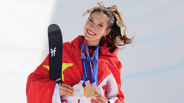 Gold medallist China's Eileen Gu poses with her medals after winning the women's freestyle skiing halfpipe final at the 2026 Winter Olympics, in Livigno, Italy, Sunday, Feb. 22, 2026. (AP Photo/Abbie Parr)