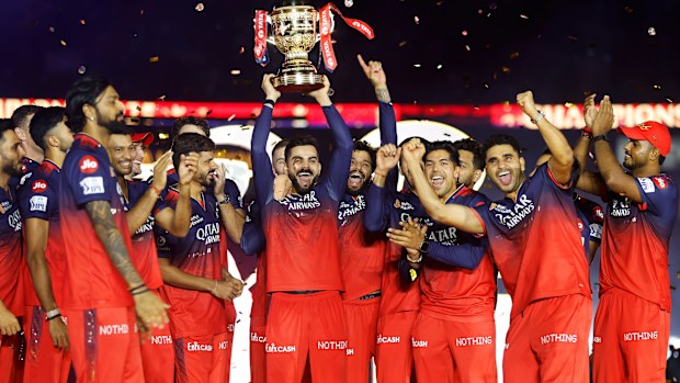 Virat Kohli of Royal Challengers Bengaluru lifts the IPL trophy alongside teammates following the team's victory in the 2025 IPL Final match between Royal Challengers Bengaluru and Punjab Kings at Narendra Modi Stadium on June 03, 2025, in Ahmedabad, India. (Photo by Pankaj Nangia/Getty Images)