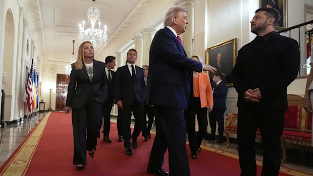 Ukrainian President Volodymyr Zelenskyy, from right, President Donald Trump, France's President Emmanuel Macron and Italy's Prime Minister Giorgia Meloni walk through the Cross Hall of the White House, Monday, Aug. 18, 2025, in Washington.