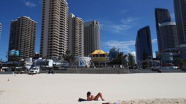 People lie on the beach at Surfers Paradise in Gold Coast, Australia. 