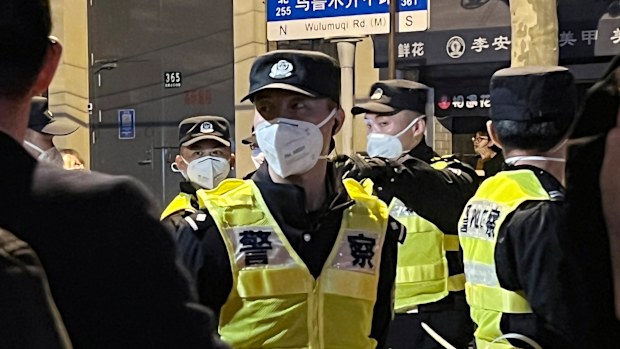 Chinese police officers block off access to a site where protesters had gathered in Shanghai.