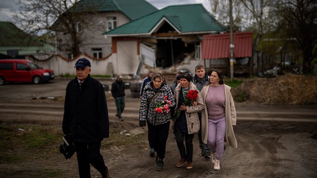 Tetiana Boikiv, 52, centre, walks with friends and neighbors during a funeral service for her husband, Mykola "Kolia" Moroz.