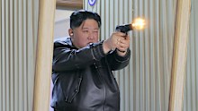 Kim Jong Un tries out a new pistol at a factory.