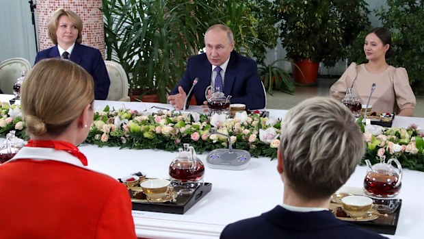 Russian President Vladimir Putin, centre, speaks to representatives of the flight crew of Russian airlines as he visits to Aeroflot Aviation School outside Moscow, Russia, Saturday, March 5, 2022 