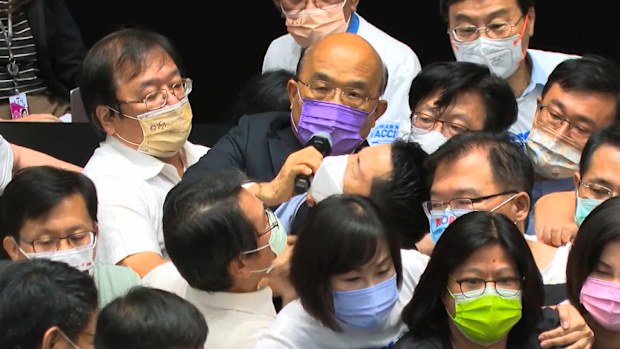 Premier Su Tseng-chang, in purple mask, tries to make a policy speech amid a scuffle between opposition Nationalist party and ruling Democratic Progressive Party lawmakers during a parliament session in Taipei. 
