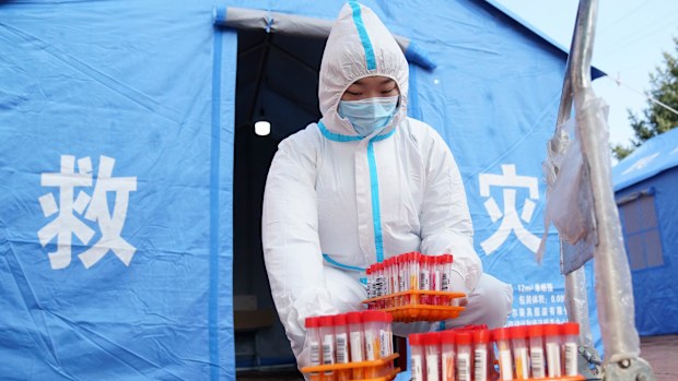 A worker in protective clothing handles COVID-19 test samples in Bayan County of Harbin city in northeastern China's Heilongjiang Province. 