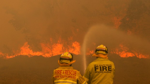 Firefighters work to contain a bushfire along Old Bar road in Old Bar, NSW, Saturday, November 9, 2019. 